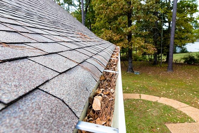 close-up of gutter downspout being cleared of debris